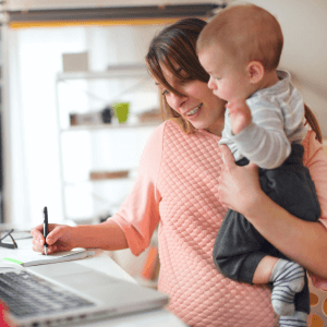 A mom working from home while holding her baby