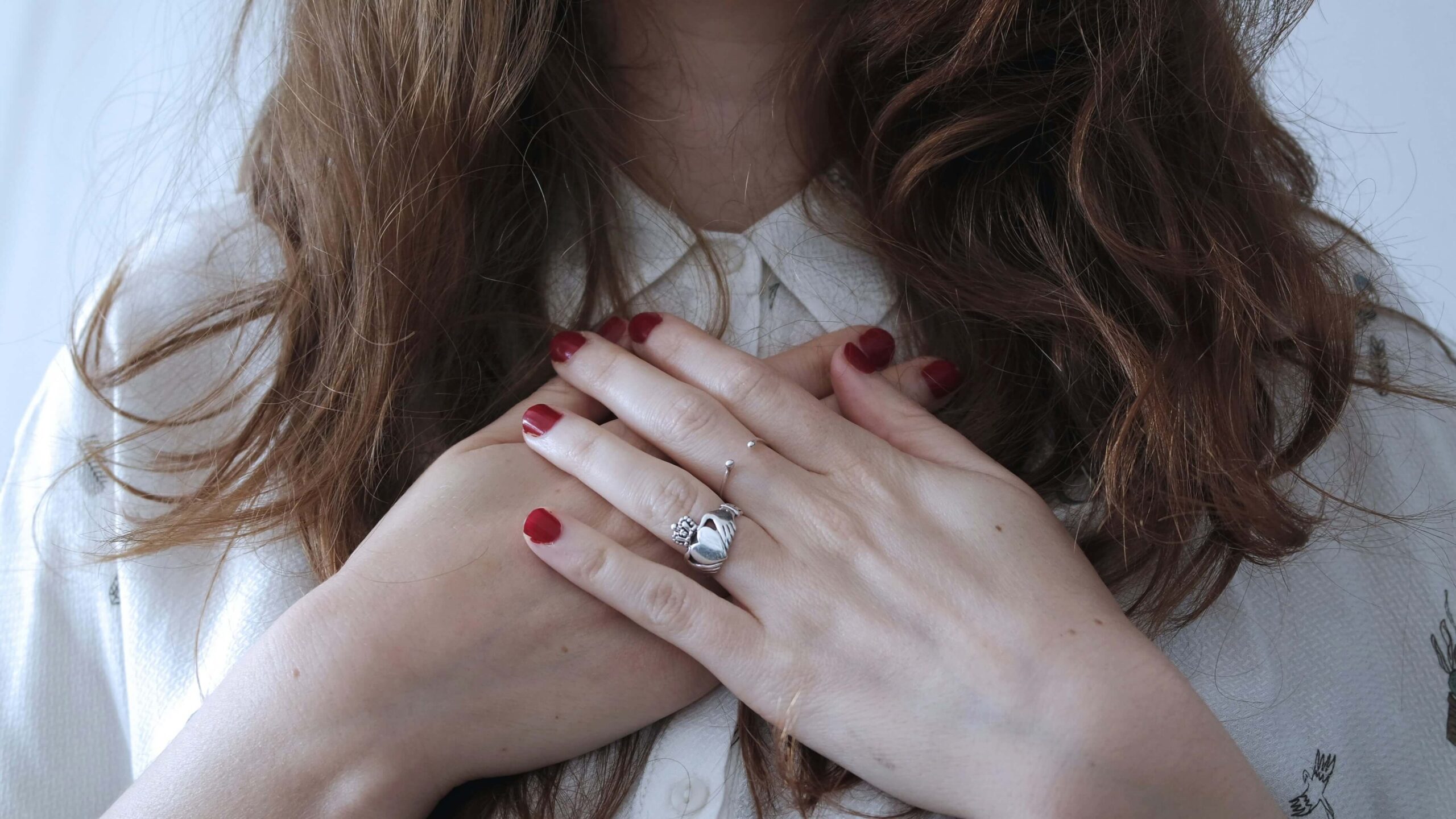 woman standing with hands over chest