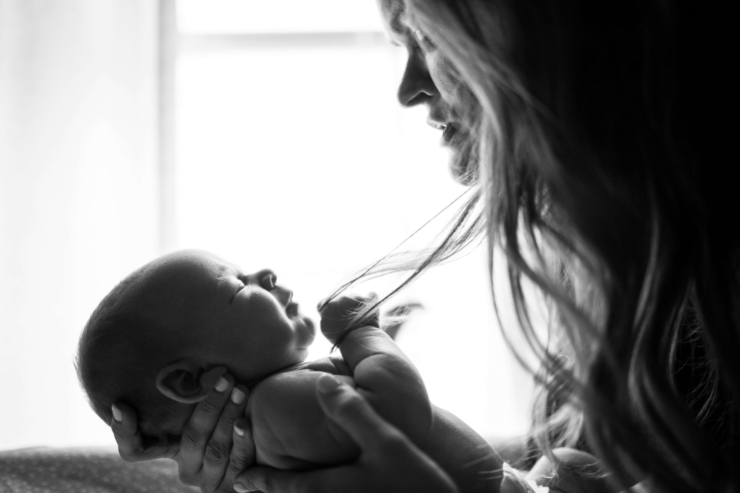 mother looking at and holding newborn baby