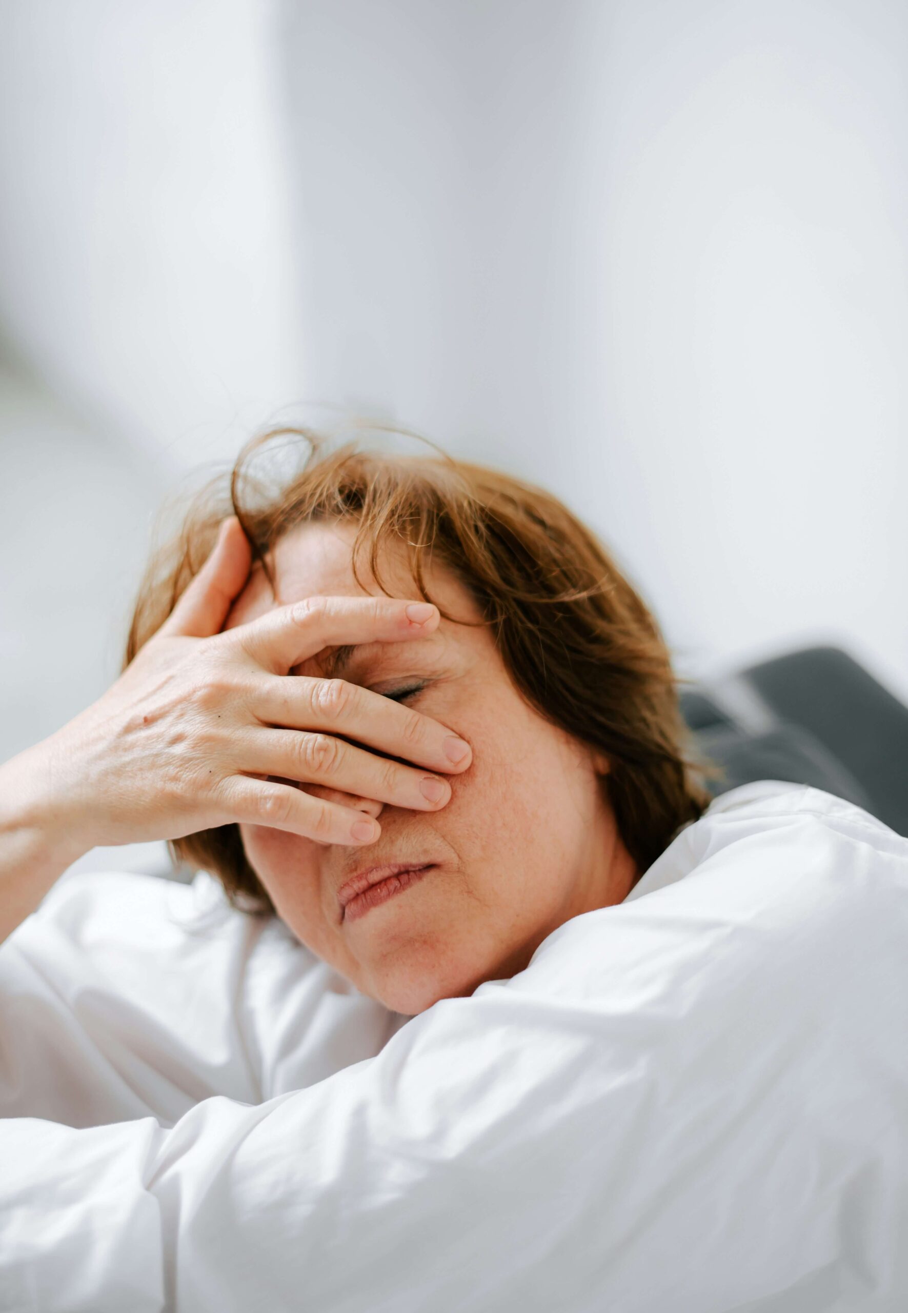 woman sitting with hand covering face