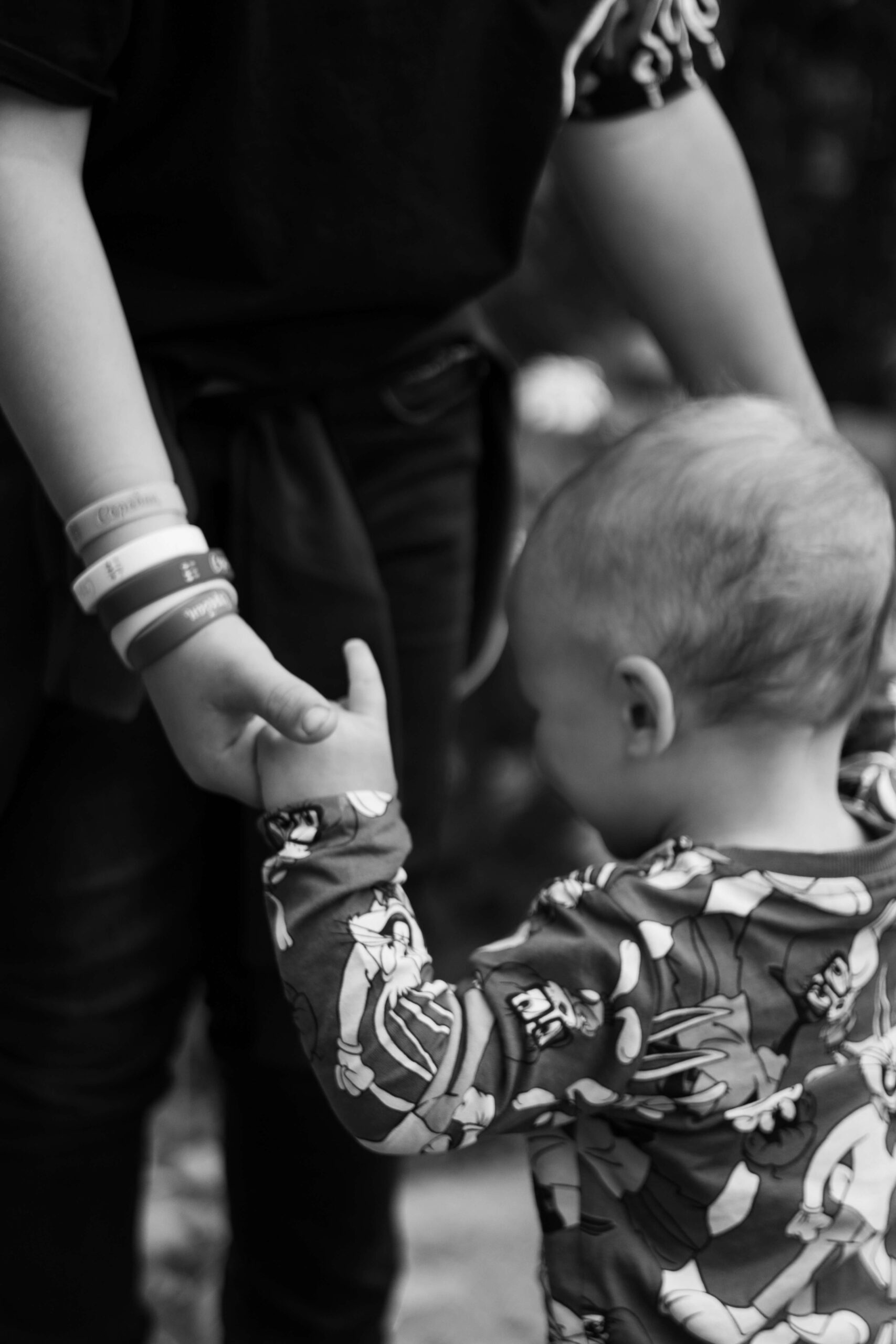 adult holding hands of young child
