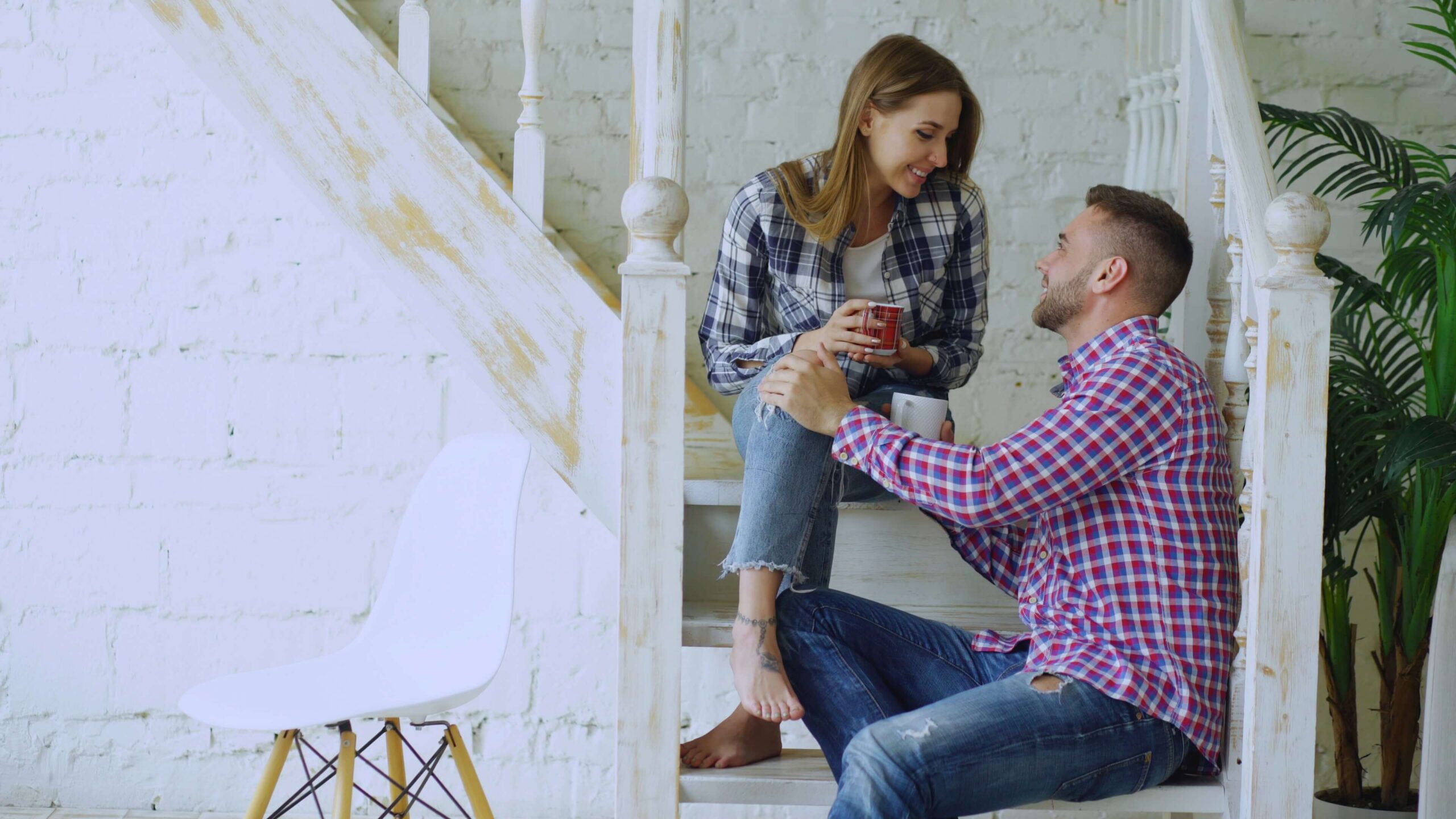 man and woman sitting on stairs smiling at each other