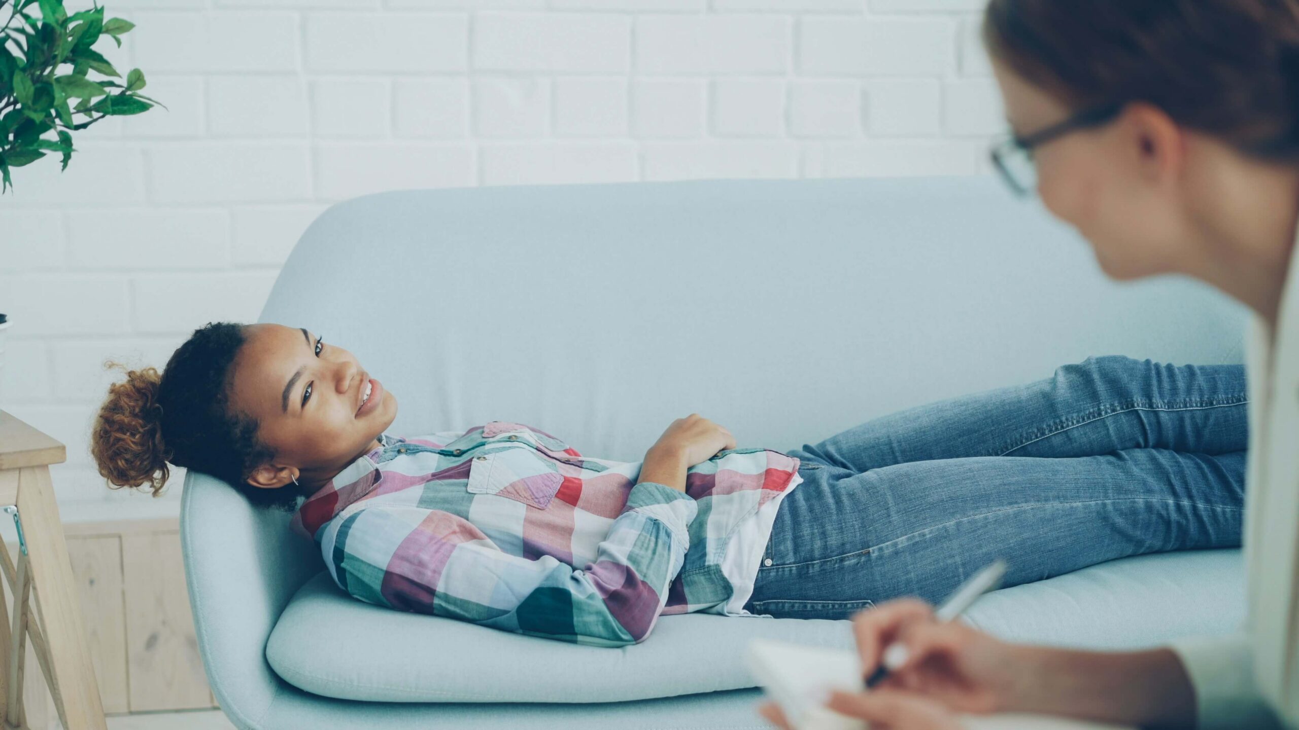 teen girl laying on couch talking to therapist
