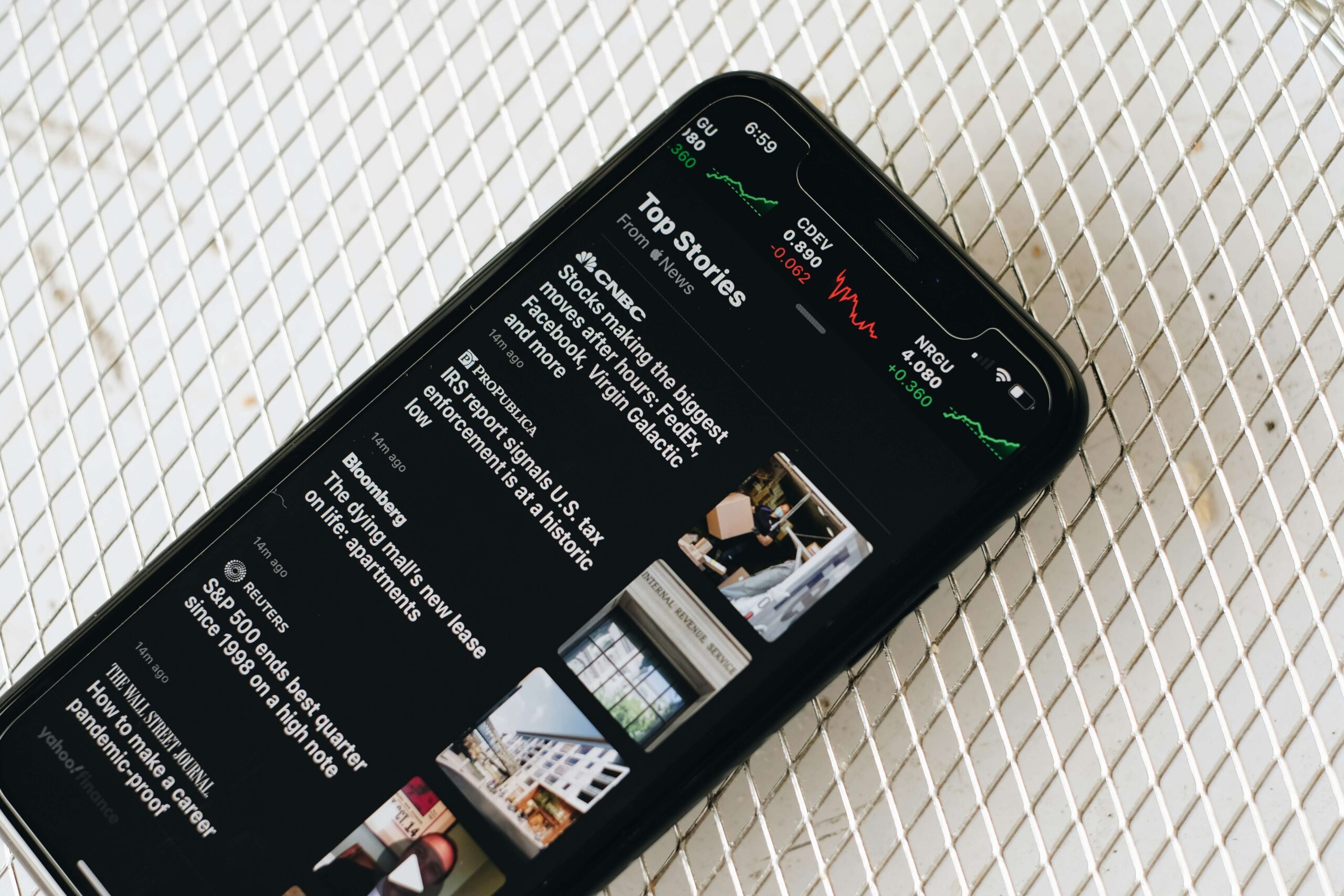 phone on table with news reports on screen
