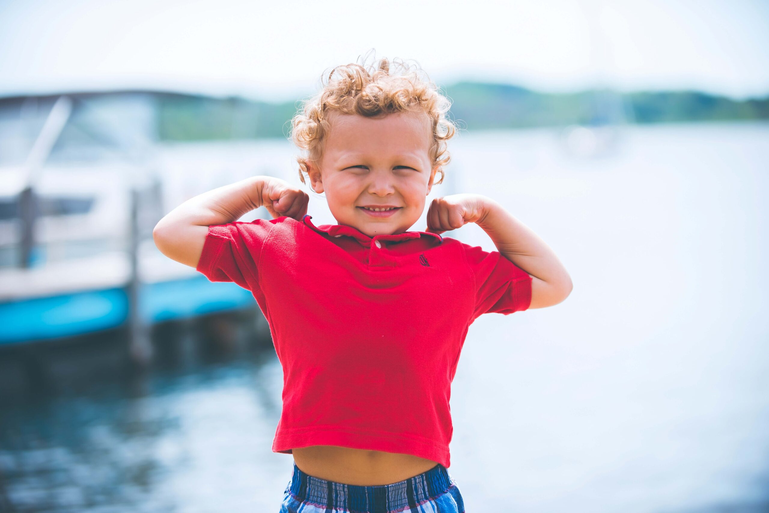 young boy showing muscles